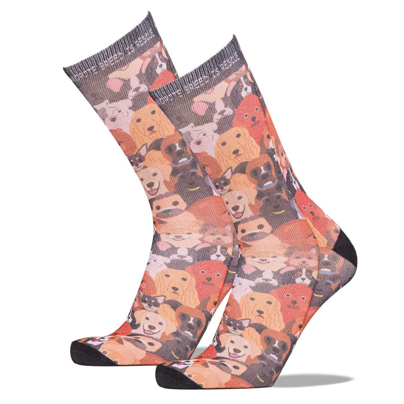 A pair of crew socks with an all-over print of cartoon dog faces, featuring black toes and heels, displayed on a clean white background.