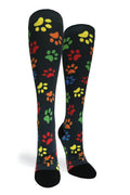 A pair of black knee-high socks with a colorful pattern of dog paw prints in yellow, green, orange, and red, shown against a plain white background.